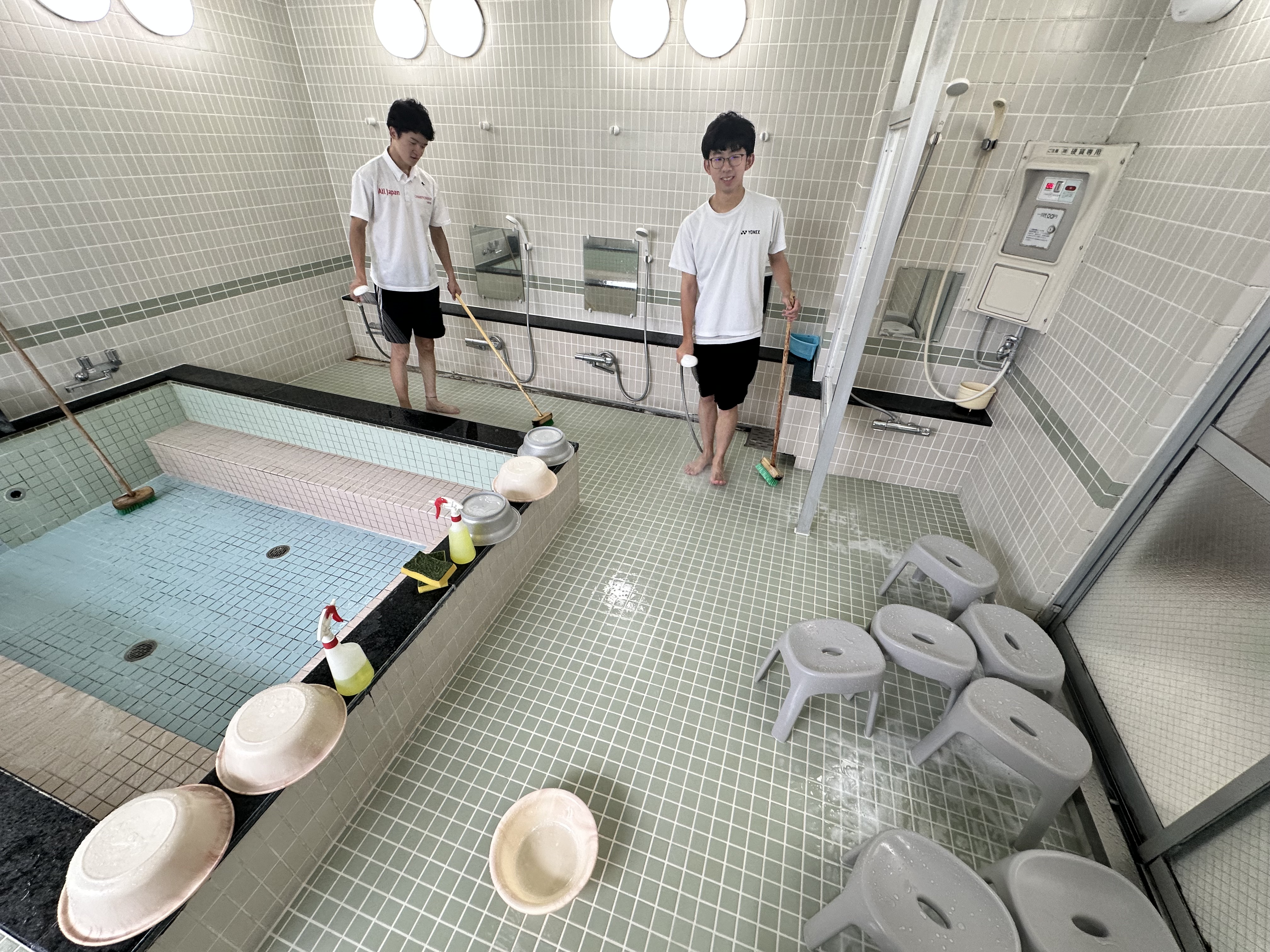 大浴場の床清掃を行う寮生たち