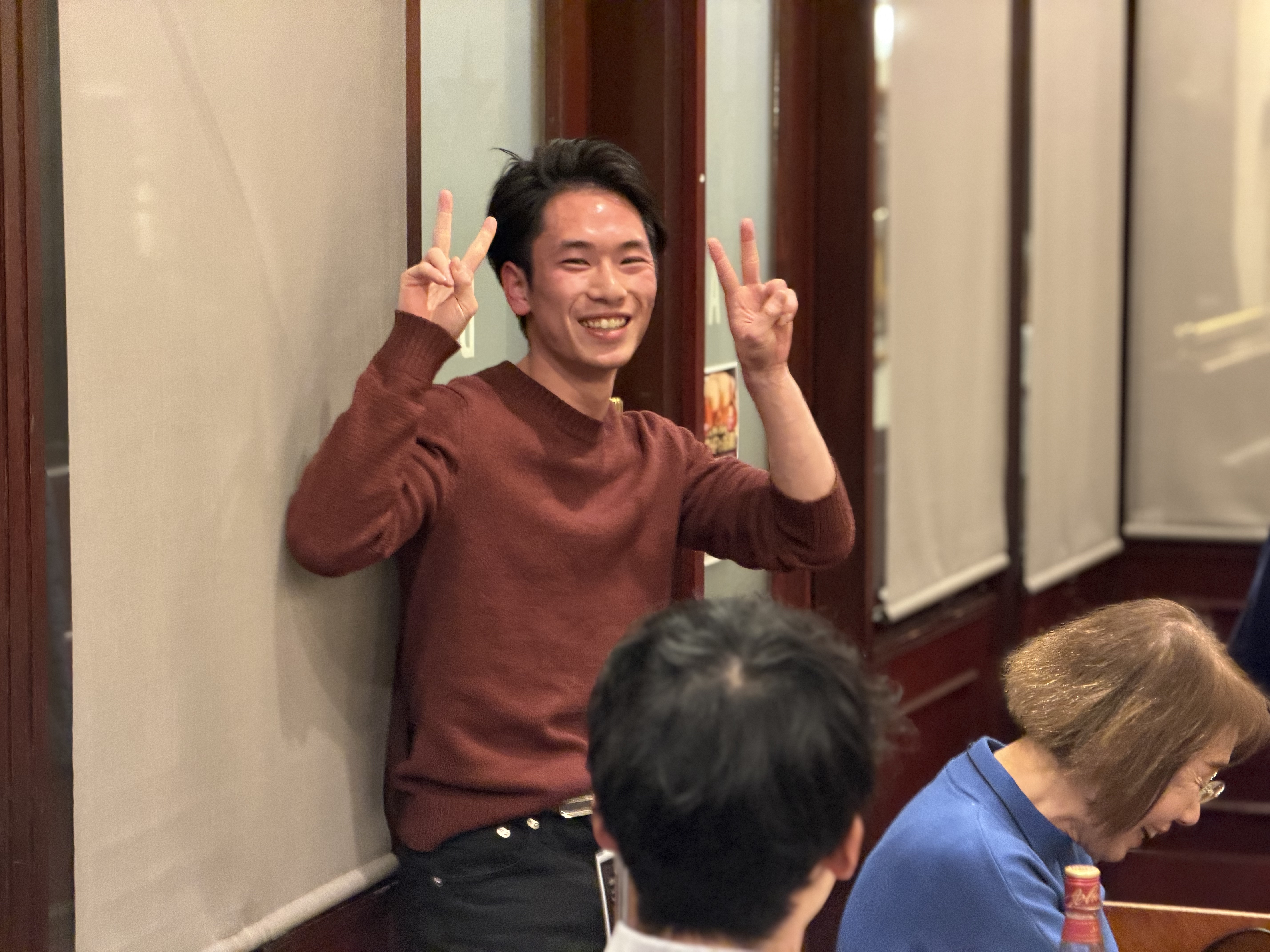 笑顔でピースサインを見せる卒寮生